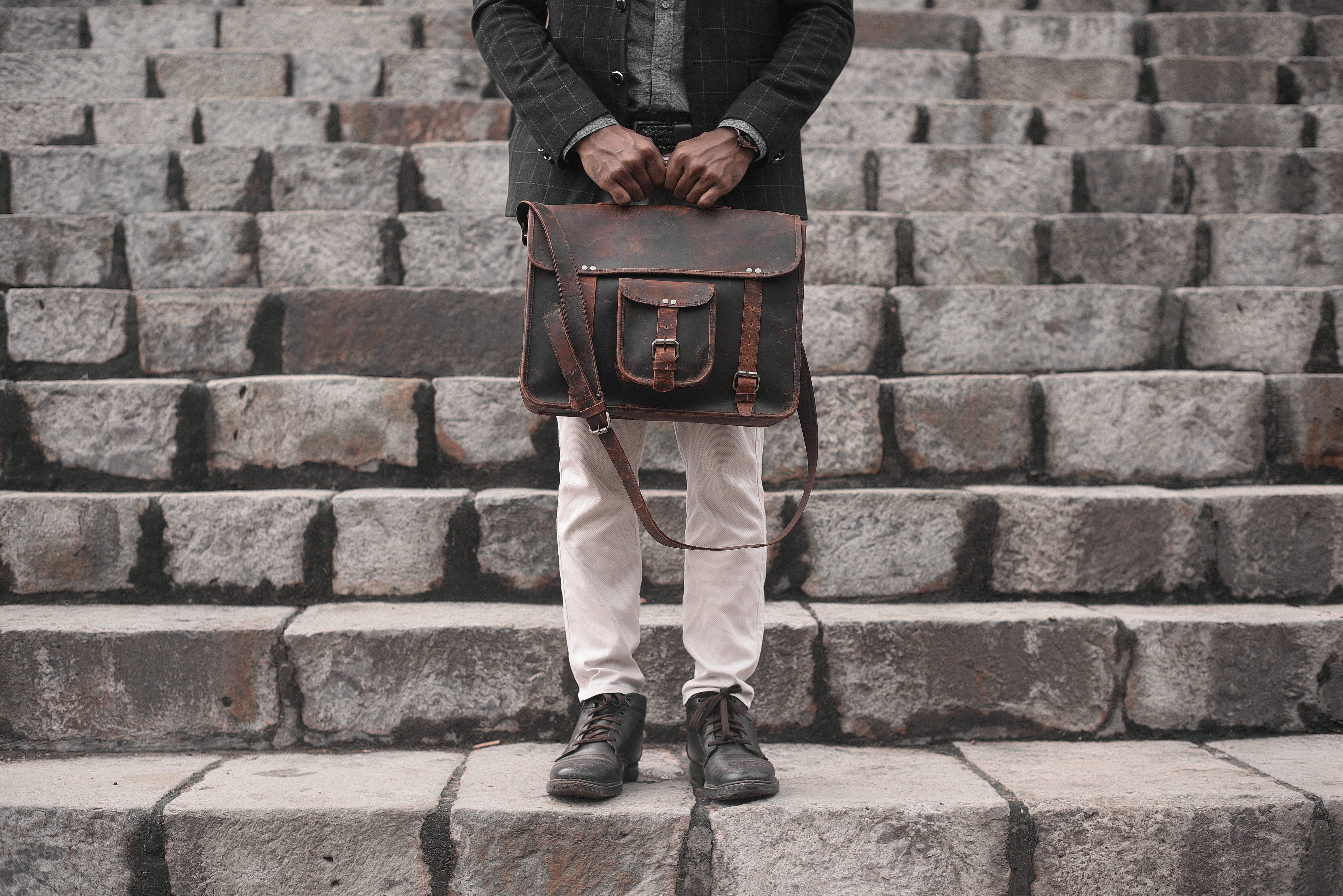 man-holding-a-leather-bag-on-a-set-of-stairs.jpg